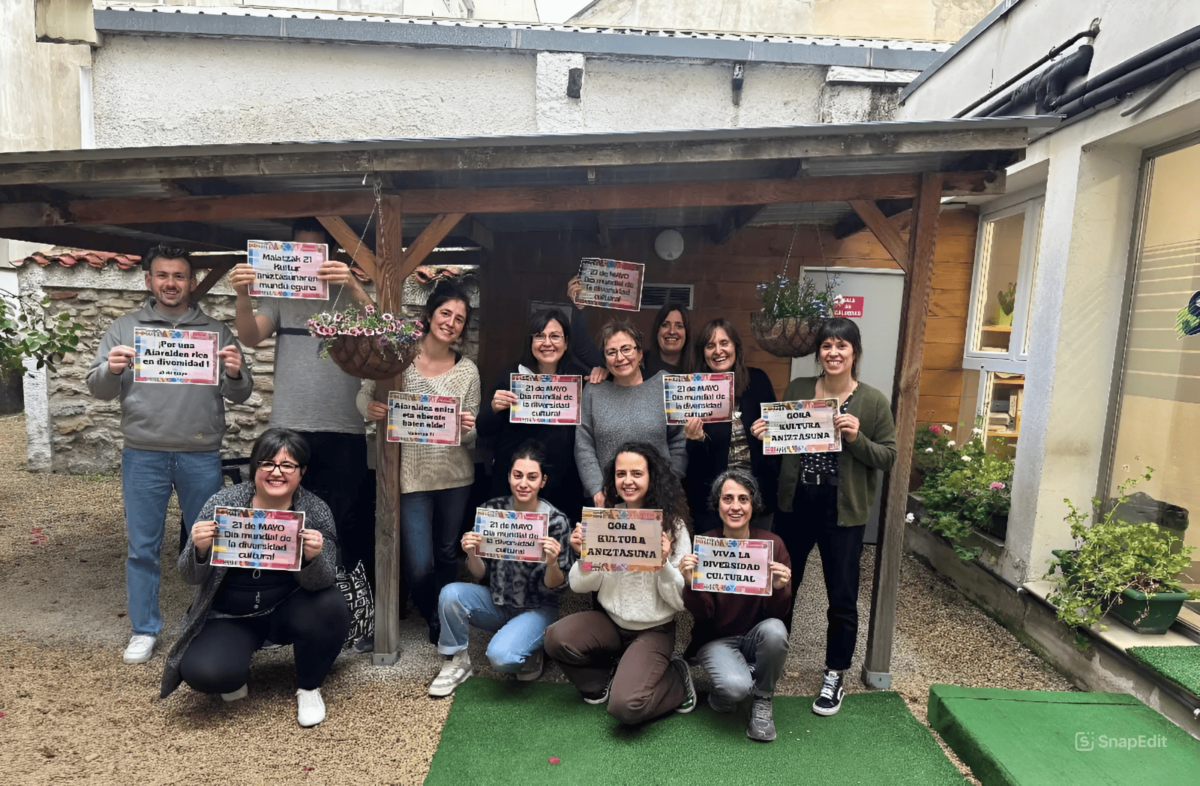 Equipo de Sartu Taldea celebrando el Día de la Diversidad Cultural con carteles conmemorativos