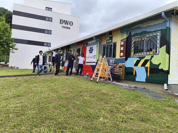 Participantes de Bidean pintando el mural comunitario de P27 Biziberritzen