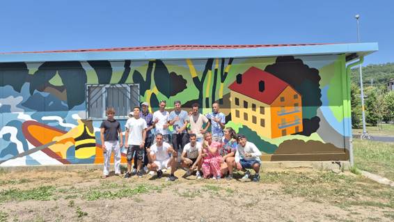 Participantes de Taller Bidean junto al mural comunitario que han realizado dentro de la iniciativa P27 Biziberritzen